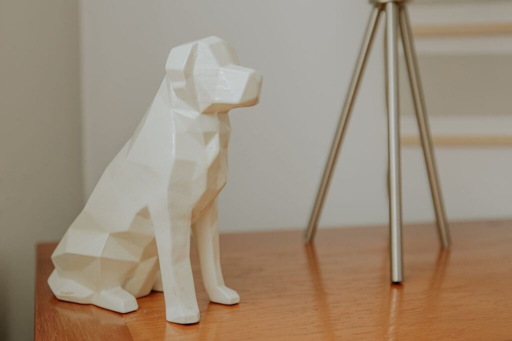 Geometric white dog figurine on a wooden table, minimalist decor with a modern touch.